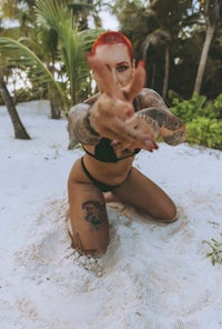 a woman in a bikini posing in the sand